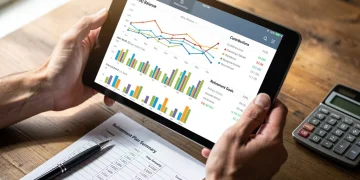 Persona analizando gráficos financieros y estado de cuenta 401(k) para optimizar la jubilación en 2026.
